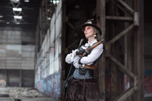 Dame âgée en costume steampunk dans une usine abandonnée avec — Photo