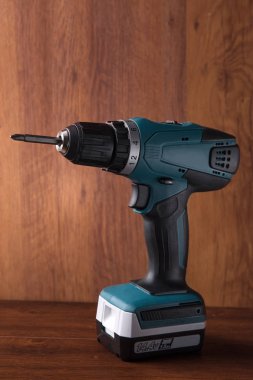 ahşap arka plan üzerinde şarj edilebilir elektrikli tornavida. Onarım bir