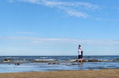 Romantik aşıklar genç çift tropikal plajda birlikte rahatlatıcı. Kadınile kucaklayan ve hayatın tadını çıkaran bir adam. Yaz tatilleri