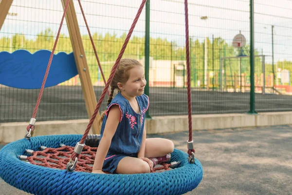 Happy little girl dziecko śmieje się i huśtawka na huśtawce w parku miejskim w lecie — Zdjęcie stockowe