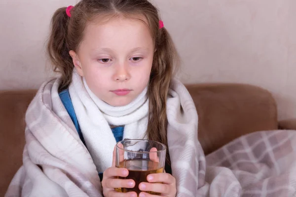 Kind dat geneesmiddel inneemt. Ziek meisje met sjaal liggend op bed — Stockfoto