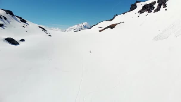 航空写真 飛んでハイカー アルプスのパノラマの景色 スキー旅行登山雪山雪に覆われた山の頂上に向かって歩いて逆境を征服 成功を達成します — ストック動画