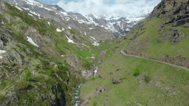 Luchtfoto Vliegen Alpine Vallei Besneeuwde Bergketen Van Schilderachtige Waterval Dramatische — Stockvideo