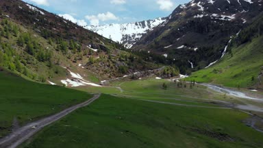 Hava ağır çekim: alp Vadisi, doğal şelale karlı dağ silsilesi ve dramatik road üzerinde İtalyan Alpleri üzerinde uçan, yaz aylarında yolculuk macera.