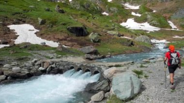 Çift backpackers patika geçiş dağ dere üzerinde hiking. Yaz macera ve explorationon Alpler.