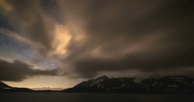 Alpler, fırtınalı gökyüzü, hareket bulutlar, karlı dağ ve göl üzerinde Astro zaman atlamalı sütlü yol galaksi yıldız.