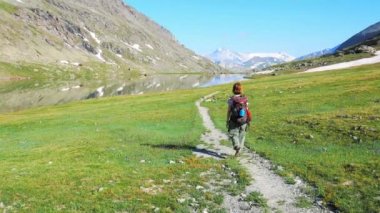 Backpacker patika pastoral dağ manzara mavi göl, yüksek dağ tepe ve buzul üzerinde hiking. Alpler maceralara yaz.