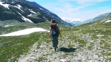 Backpacker pastoral dağ manzarası ile yüksek dağ tepe ve buzul patika üzerinde hiking. Alpler yaz maceralara. Ağır çekim.