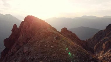 Anteni: Backpacker alpinist dağ üst, kayalık dağ tepe tarayıcı arka aydınlatma, doğal manzara, hiking. Ağır çekim. Alpler yaz maceralara. Fetih başarı lider kavramı.