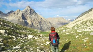 Yüksek dağ tepe, Dolomites, İtalya ile doğal peyzaj patika üzerinde hiking backpacker kadın. Alpler maceralara yaz