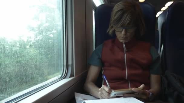Woman Using Smart Phone Sitting Traveling Train Hand Writing Paper — Stock Video