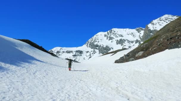 ハイカーは 雪に覆われた山の頂上 スキー ツアー冬の活動 登山雪山に向かって歩いて 逆境を征服 アルプスのパノラマの景色は 成功を達成します — ストック動画