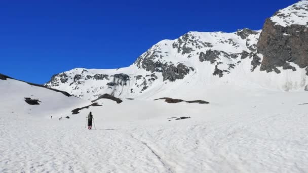 ハイカーは 雪に覆われた山の頂上 スキー ツアー冬の活動 登山雪山に向かって歩いて 逆境を征服 アルプスのパノラマの景色は 成功を達成します — ストック動画