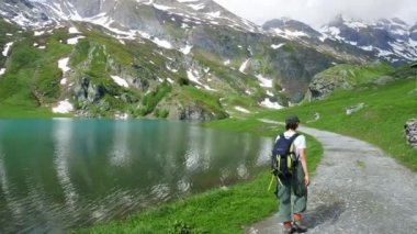 Kadın mavi göl üzerinde Alps hiking yaz, karlı dağ silsilesi, yolculuk tutkusu kavramı