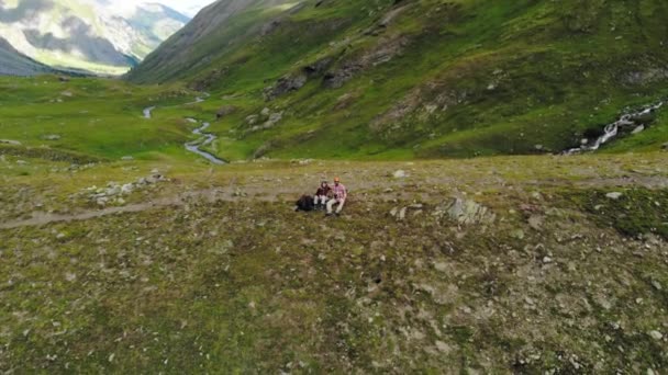 の上に座ってカップル ハイカーは湿原の高山の谷で トップダウン ビュー アルプスのワンダー ラストの夏の冒険 映画見てカラーグレーディング ロイヤリティフリーストック映像