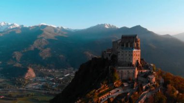Hava: eski ortaçağ abbey adlı uçan uçak dağın tepesinde, gündoğumu, karlı Alpler'in çarpıcı arka plan üzerinde tünemiş. Sacra di San Michele (İtalyan) - Saint Michel Abbey (İngilizce traslation) - Torino, İtalya