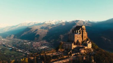 Hava: eski ortaçağ abbey adlı uçan uçak dağın tepesinde, gündoğumu, karlı Alpler'in çarpıcı arka plan üzerinde tünemiş. Sacra di San Michele (İtalyan) - Saint Michel Abbey (İngilizce traslation) - Torino, İtalya