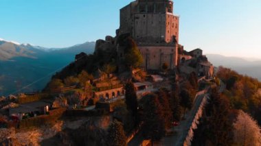 Hava: eski ortaçağ abbey adlı uçan uçak dağın tepesinde, gündoğumu, karlı Alpler'in çarpıcı arka plan üzerinde tünemiş. Sacra di San Michele (İtalyan) - Saint Michel Abbey (İngilizce traslation) - Torino, İtalya