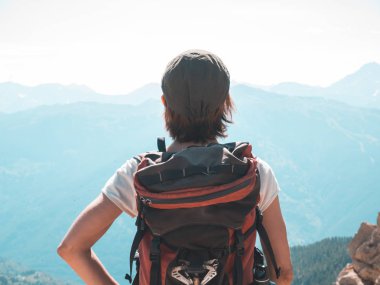 Bir kişi backpacker Alpler üzerinde yüksek rütbeli manzaraya bakarak. Expasive manzara, gün batımında pastoral görünümü. Arkadan Görünüş, tonlu görüntü.