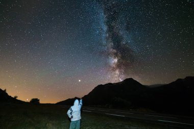 Yıldızlı gökyüzü ve Samanyolu Alpler üzerinde yüksek irtifada bakarak bir kişi yıldızlara. Mars gezegeni solda. Macera ve keşif yaz aylarında.
