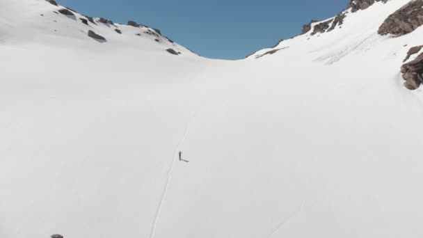 航空写真 アルプスのパノラマ ビュー スキーツアー登山雪山雪に覆われた山の頂上に向かって歩くハイカーの上を飛んでください ネイティブ Cinelike ログ区間カラー プロファイル — ストック動画