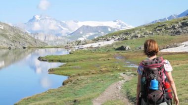 Backpacker patika pastoral dağ manzara mavi göl, yüksek dağ tepe ve buzul üzerinde hiking. Alpler maceralara yaz.