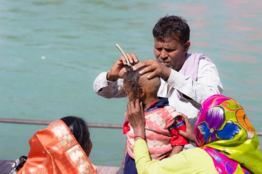 Harid, Hindistan - 20 Mart 2017: kıllar Haridwar, Hindistan Ganj nehir üzerinde genç Hindu devotee başlatılması için kapalı tıraş dostum.