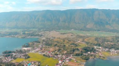 Havadan: Sumatra Endonezya yukarıda göl Toba ve Samosir Adası görünümü. Su, geleneksel batak köyleri, yeşil pirinç tarlaları, Ekvator ormanı ile kaplı büyük volkanik Kaldera. Deniz mavisi turuncu sınıflandırma.