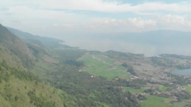 Havadan: Sumatra Endonezya yukarısında Toba ve Samosir Adası Gölü. Su, batak köyleri, yeşil pirinç tarlaları, Ekvator ormanı ile kaplı büyük volkanik Kaldera. Yerel cinelike D-log renk profili.