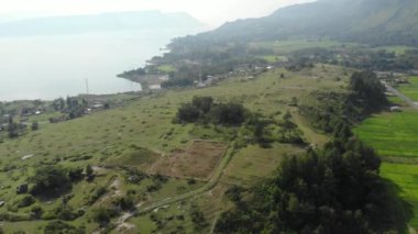 Havadan: Sumatra Endonezya yukarısında Toba ve Samosir Adası Gölü. Su, batak köyleri, yeşil pirinç tarlaları, Ekvator ormanı ile kaplı büyük volkanik Kaldera. Yerel cinelike D-log renk profili.