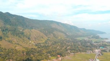 Havadan: Sumatra Endonezya yukarıda göl Toba ve Samosir Adası görünümü. Su, geleneksel batak köyleri, yeşil pirinç tarlaları, Ekvator ormanı ile kaplı büyük volkanik Kaldera. Deniz mavisi turuncu sınıflandırma.