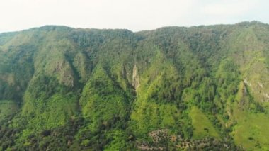 Hava: Toba Gölü ve Sumatra Endonezya 'dan Samosir Adası manzarası. Büyük volkanik kaldera suyla kaplı, geleneksel Batak köyleri, yeşil pirinç tarlaları, ekvatoral orman.