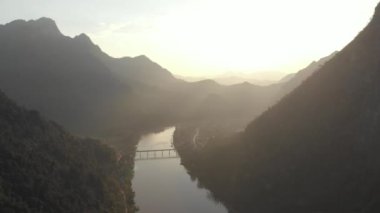 Havadan: Nam OU Nehri Nong Khiaw Muang Ngoi Laos üzerinde uçan, günbatımı dramatik gökyüzü, doğal dağ manzara, Güney Doğu Asya 'da ünlü seyahat yeri. Yerel cinelike D-log renk profili.