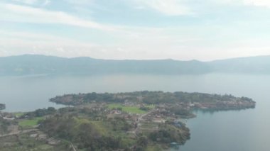 Havadan: Sumatra Endonezya yukarısında Toba ve Samosir Adası Gölü. Su, batak köyleri, yeşil pirinç tarlaları, Ekvator ormanı ile kaplı büyük volkanik Kaldera. Yerel cinelike D-log renk profili.