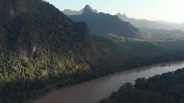 Havadan: Nam OU Nehri Nong Khiaw Muang Ngoi Laos üzerinde uçan, günbatımı dramatik gökyüzü, doğal dağ manzara, Güney Doğu Asya 'da ünlü seyahat yeri. Yerel cinelike D-log renk profili.