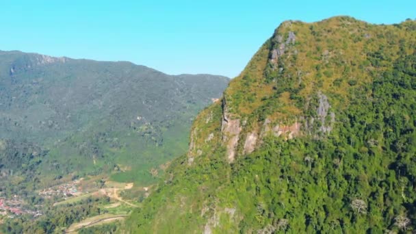 自然の熱帯雨林の緑のジャングルの上に飛んでドローンは北ラオスの山に急な谷の崖を設定します 東南アジアの旅行先 — ストック動画