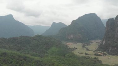 Havadan: doğal kayalıklar üzerinde uçan Pinnacles tropikal orman pirinç tarlaları Valley çarpıcı manzara Vang Vieng etrafında Laos Asia popüler hedef. Yerel cinelike D-log renk profili