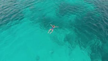 Havadan: kadın turkuaz su mercan resifi tropikal Karayip Deniz Endonezya Sulawesi Wakatobi Marine National Park, turist dalış seyahat hedef üzerinde yüzme. Yerel cinelike D-log renk profili.
