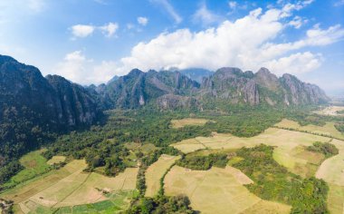 Hava: Vang Vieng backpacker seyahat hedef Laos, Asya. Doğal kayalıklarla ve rock pinnacles, üzerinde dramatik gökyüzü manzara muhteşem pirinç paddies Vadisi.