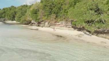 Andan: tropikal ada turkuaz su beyaz kum plajda yürüyen kadın, Tomia Adası, Wakatobi deniz milli parkı, Endonezya, Yerli cinelike D-günlük renk profili