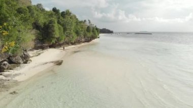 Andan: tropikal ada turkuaz su beyaz kum plajda yürüyen kadın, Tomia Adası, Wakatobi deniz milli parkı, Endonezya, Yerli cinelike D-günlük renk profili