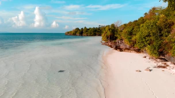 Cámara lenta aérea: mujer caminando en la playa de arena blanca de agua turquesa de la isla tropical, isla Tomia, parque nacional marino de Wakatobi, Indonesia, clasificación naranja azulado — Vídeo de stock