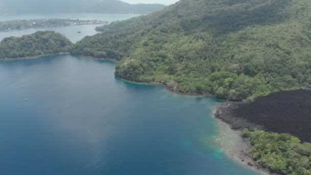 Aérea: volando sobre las Islas Banda volcán activo Gunung Api flujos de lava Maluku Indonesia exuberante bosque verde turquesa agua arrecife de coral pintoresco destino de viaje. Perfil de color D-log cinelike nativo — Vídeos de Stock