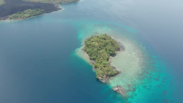 Aerial: pływające nad wyspy banda aktywny wulkan Gunung API lawy Maluku Indonezji bujny zielony las turkusowy woda koralowa rafa malownicze miejsce podróży. Natywny profil kolorów D-log — Wideo stockowe