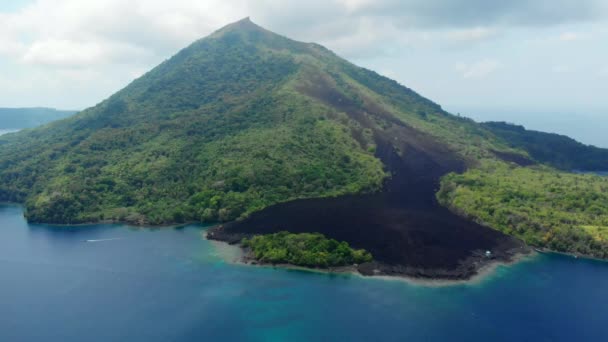 航空写真:バンダ諸島の活火山グヌンアピ溶岩の上を飛ぶマルクインドネシア緑豊かな緑の森ターコイズ水サンゴ礁の風光明媚な旅行先 — ストック動画
