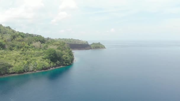 Aérea: volando sobre las Islas Banda volcán activo Gunung Api flujos de lava Maluku Indonesia exuberante bosque verde turquesa agua arrecife de coral pintoresco destino de viaje. Perfil de color D-log cinelike nativo — Vídeos de Stock