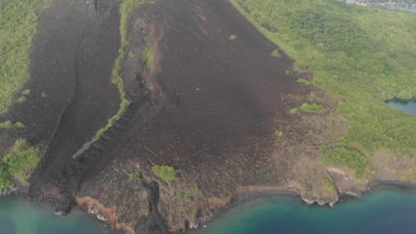 Aéreo: sobrevoando as Ilhas Banda vulcão ativo Gunung Api fluxos de lava Maluku Indonésia exuberante floresta verde turquesa recife de coral de água destino de viagem cênica. Perfil de cor nativo cinelike D-log — Vídeo de Stock