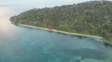 Hava: tropikal Hatta adası beyaz kum plaj Banda Adaları Maluku Endonezya yemyeşil orman turkuaz su mercan resifi doğal seyahat hedef üzerinde uçan. Yerli cinelike D-log renk profili