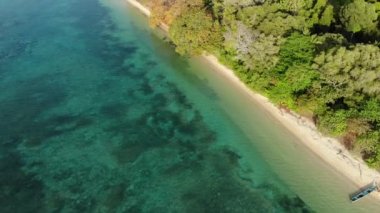 Hava: tropikal Hatta adası beyaz kum plaj Banda Adaları Maluku Endonezya yemyeşil orman turkuaz su mercan resif ilerler günbatımı gökyüzü üzerinde uçan. Yerli cinelike D-log renk profili