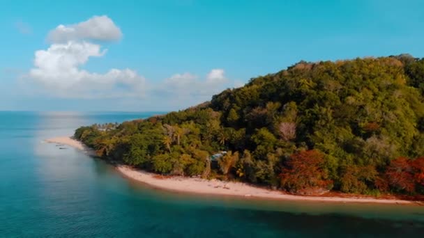 Aéreo: sobrevoando tropical Hatta ilha praia de areia branca Ilhas Banda Maluku Indonésia exuberante floresta verde turquesa recife de coral de água céu por do sol — Vídeo de Stock
